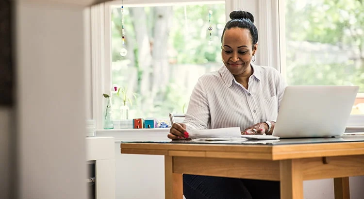 Downsizing your home- woman working on laptop in kitchen